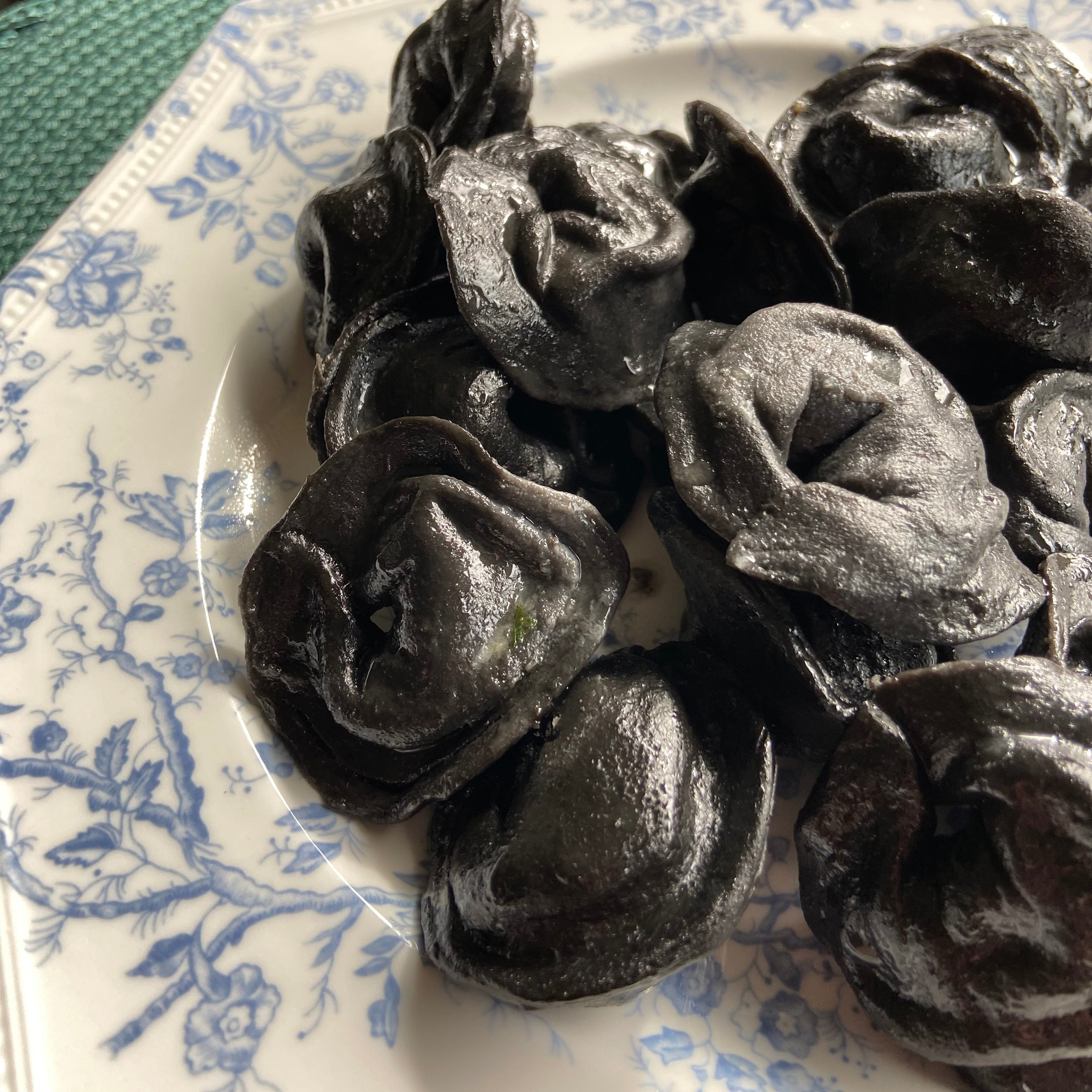 Hand-made black squid ink pierogi with salmon