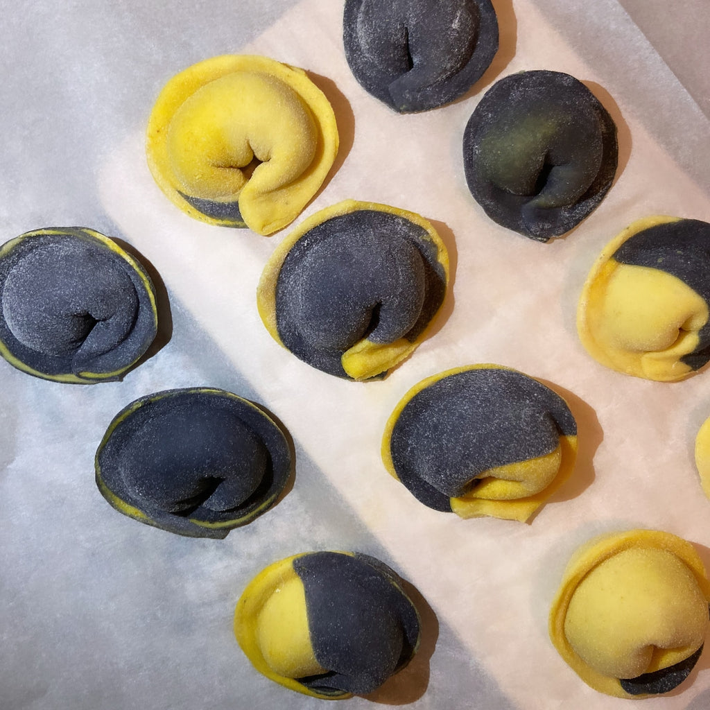 Hand-made black squid ink pierogi with salmon